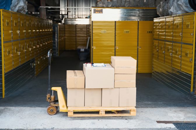 Loaded cargo trolley in a warehouse, there are many cardboard boxes and a tablet on it